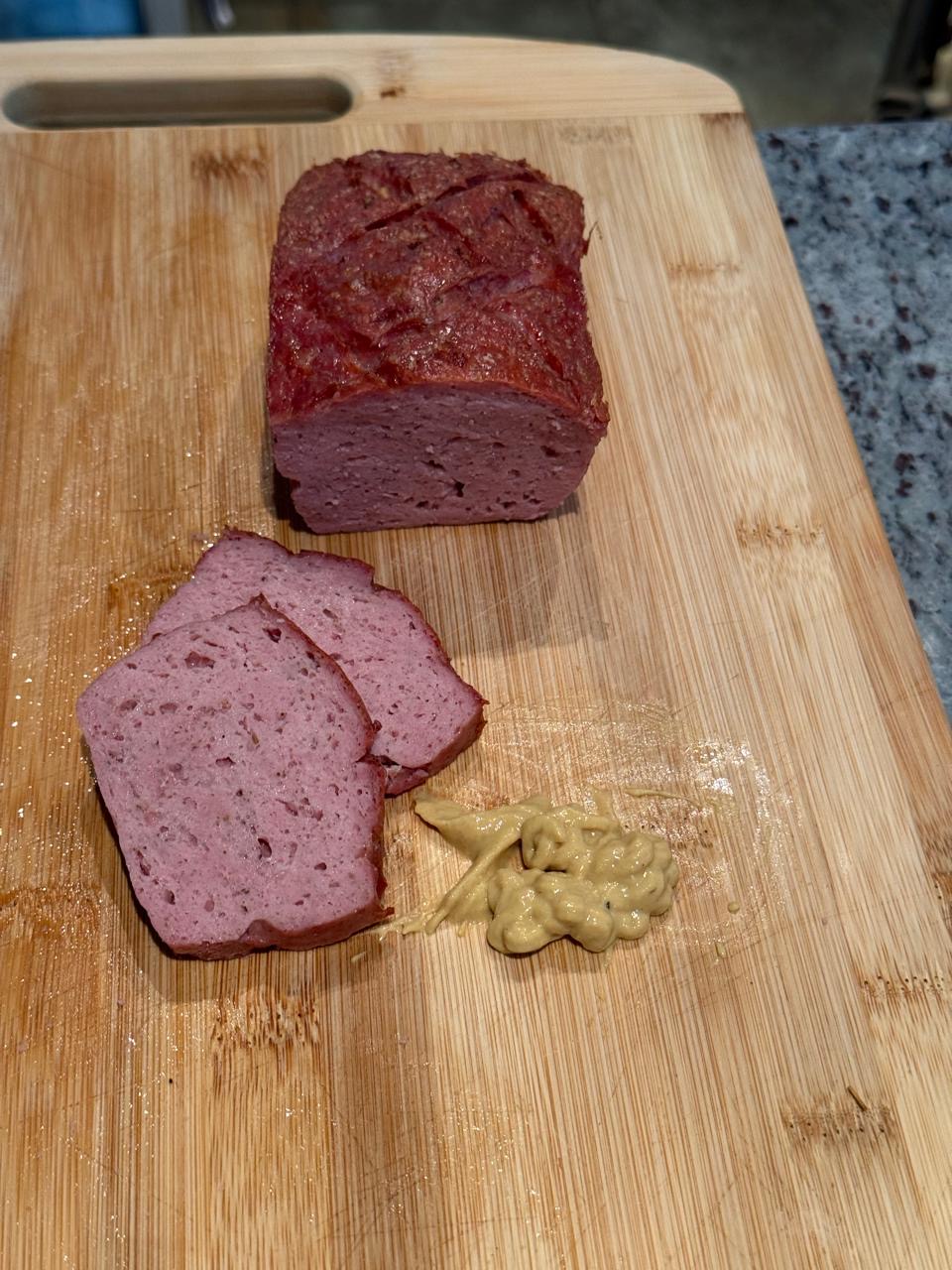 Classic Leberkäse sliced on the board with mustard, Red Thorn Farm